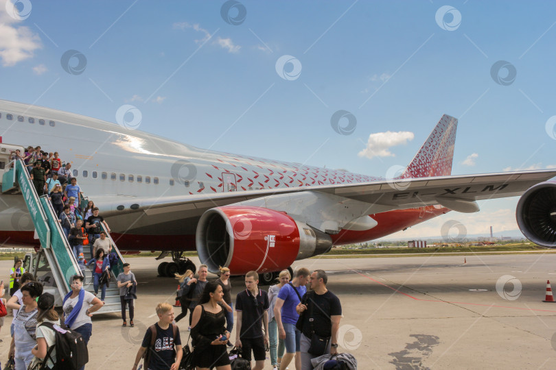 Скачать Люди спускаются по трапу из самолета. фотосток Ozero