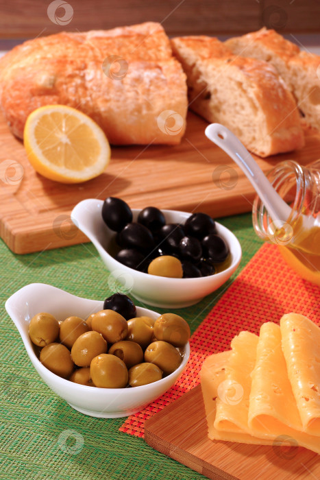 Скачать Черные и зеленые оливки, сыр, бутылочка с маслом и домашний хлеб фотосток Ozero