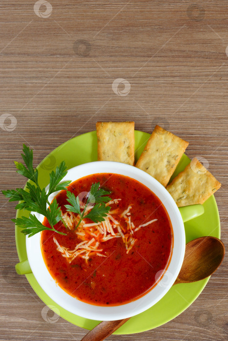 Скачать Томатный суп в зеленой чашке на деревянном столе. Вид сверху. фотосток Ozero