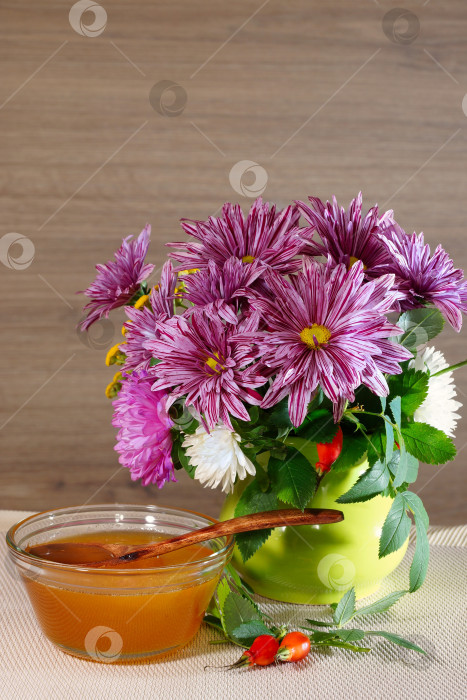 Скачать Ваза с хризантемой и стеклянная ваза с медом на деревянном фоне фотосток Ozero