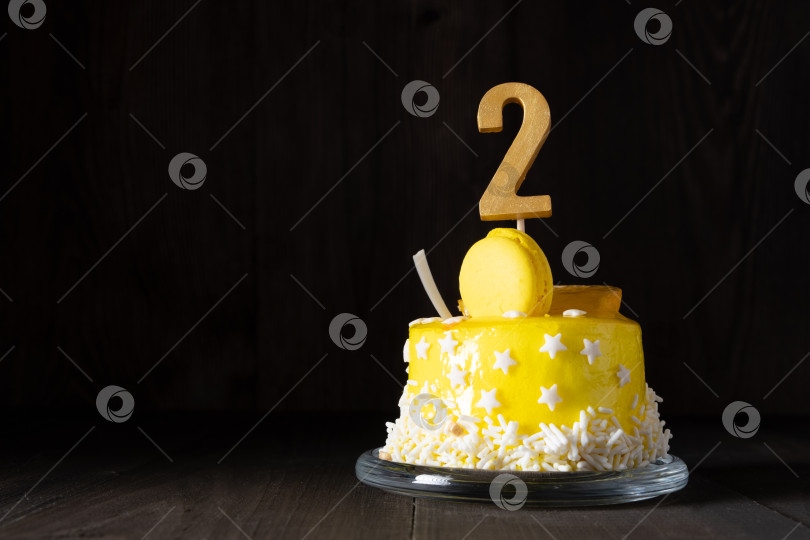 Скачать Цифра два на желтом торте на годовщину или день рождения в темной тональности. фотосток Ozero