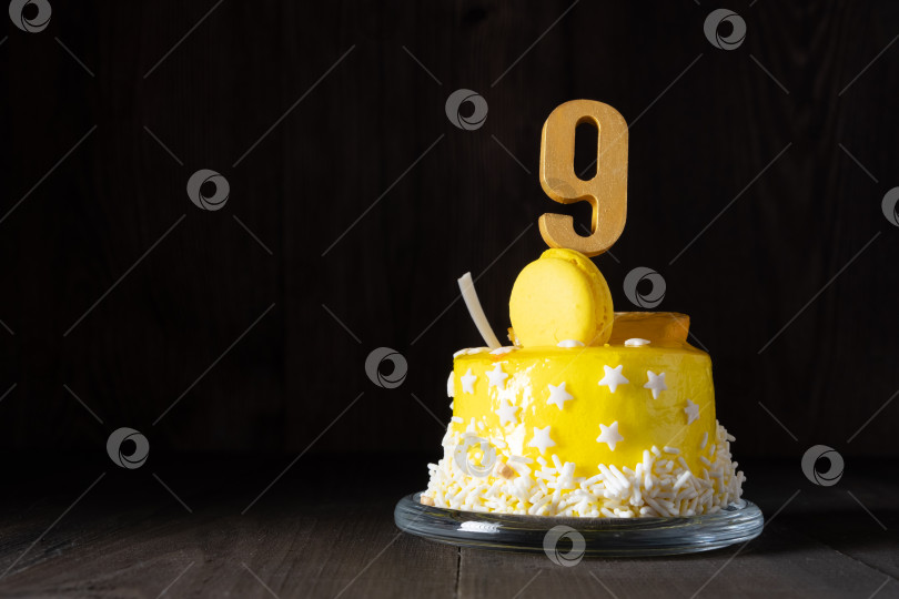 Скачать Цифра девять на желтом торте на годовщину или день рождения в темной тональности. фотосток Ozero