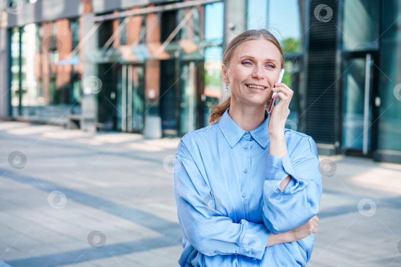 Скачать Деловая женщина с телефоном возле офиса. Портрет красивой улыбающейся девушки фотосток Ozero