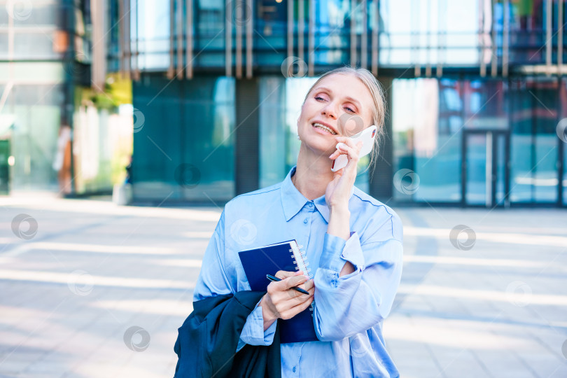 Скачать Умная профессиональная кавказская деловая женщина пользуется мобильным телефоном в городе на открытом воздухе фотосток Ozero