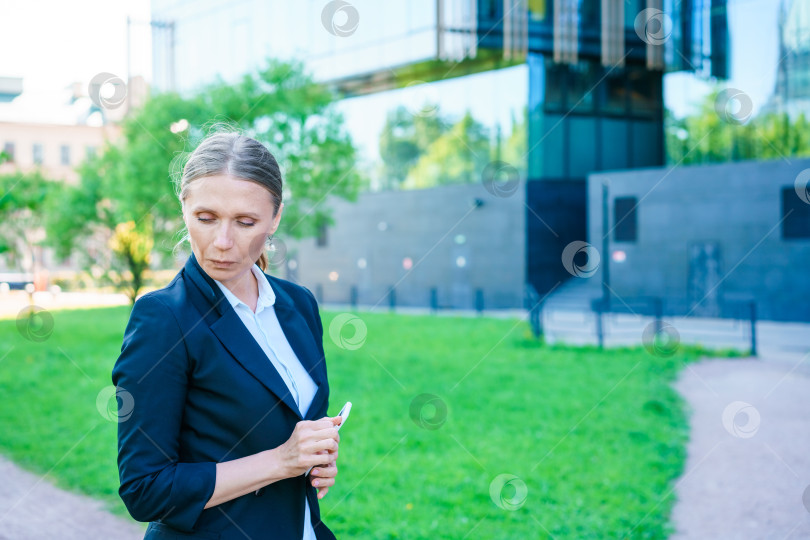 Скачать Улыбающаяся деловая женщина в костюме, стоящая на городской улице на фоне фотосток Ozero