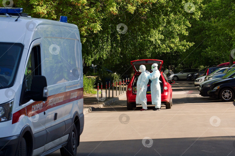 Скачать Москва, Россия- 7 июня 2020. Врачи надевают защитный костюм перед посещением пациента с новой коронавирусной инфекцией фотосток Ozero