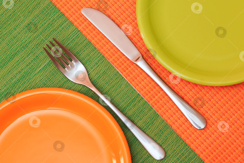 Скачать Две пустые тарелки, оранжевая и зеленая. Вид сверху фотосток Ozero