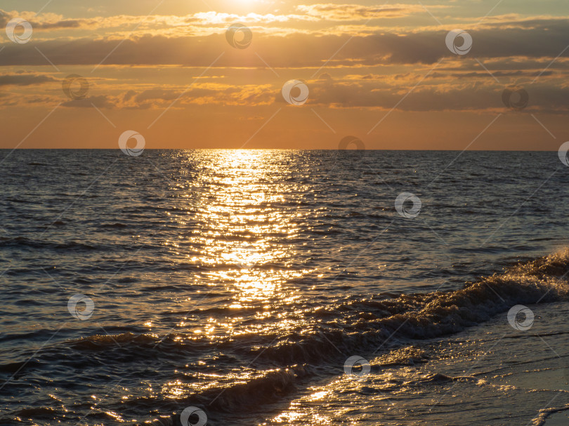 Скачать Морской пейзаж на закате над морем. Мягкие морские волны омывают фотосток Ozero