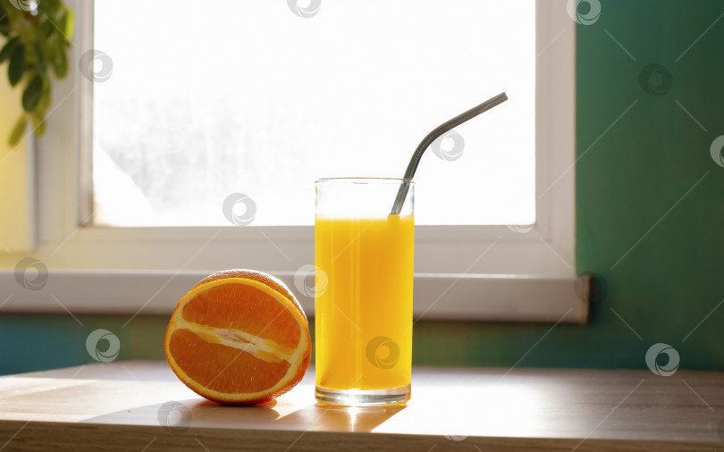 Скачать Красивый апельсиновый фрукт и стакан сока с железной трубочкой без пластика возле окна на столе реалистичная картинка фотосток Ozero