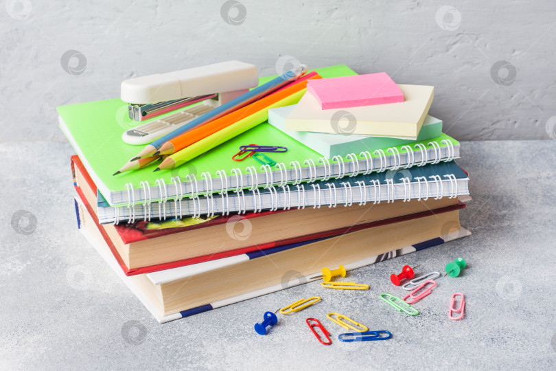 Скачать Школьные принадлежности, книги, тетради, карандаши на сером фоне с местом для копирования. фотосток Ozero