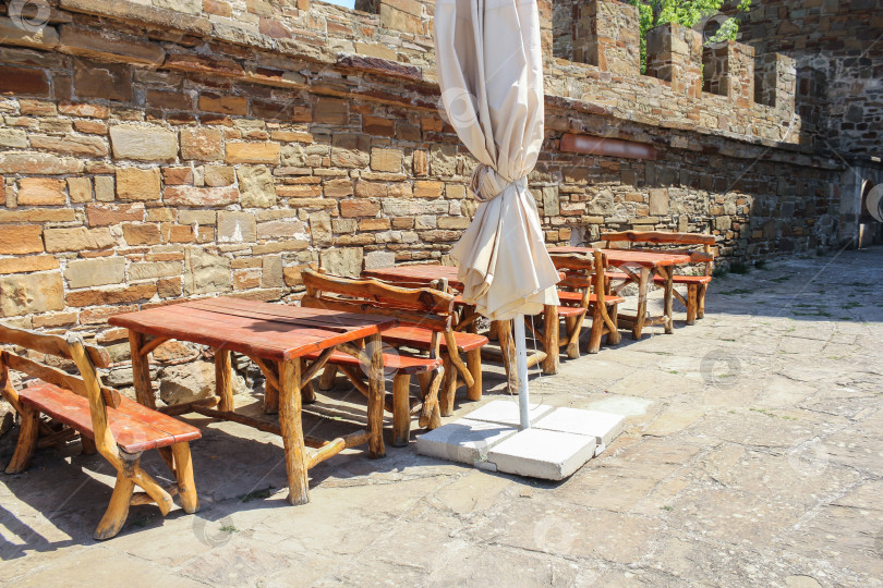 Скачать Деревянные скамейки со столами у стены. фотосток Ozero