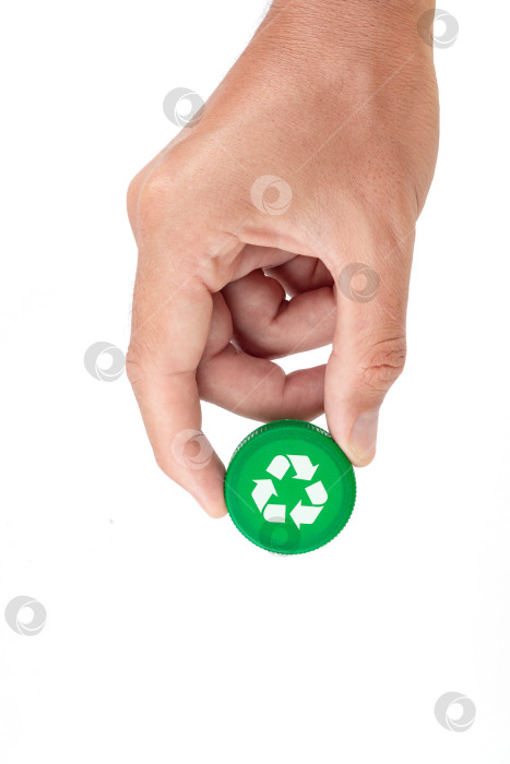 Скачать Рука, держащая зеленую пластиковую крышку для вторичной переработки на белом фоне. Концепция вторичной переработки фотосток Ozero
