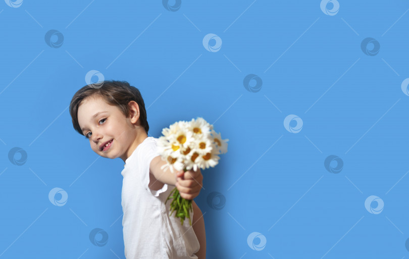 Скачать Счастливый красивый малыш мальчик держит букет цветов на желтом фоне. Дети любят природу и счастливую природу современной жизни фотосток Ozero