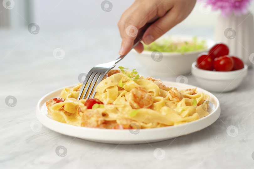 Скачать Итальянская паста фетучини с креветками в белой миске на сером столе. Крупным планом красивая картинка домашней национальной кухни фотосток Ozero