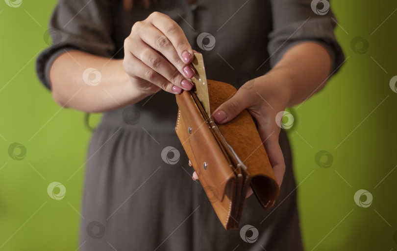 Скачать Неузнаваемые женские руки кладут кредитную банковскую карту в бумажник крупным планом фотосток Ozero