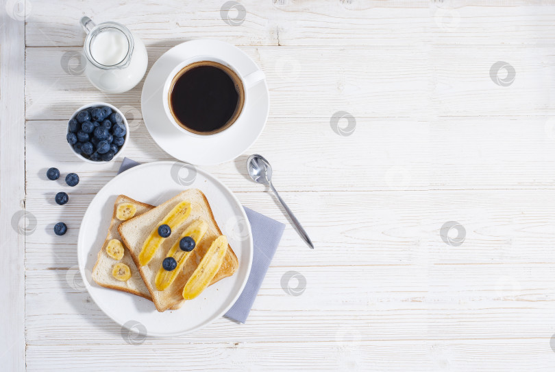 Скачать Завтрак с бананами и черникой с чашкой кофе, запеченные тосты на белом столе flatlay copy space фотосток Ozero