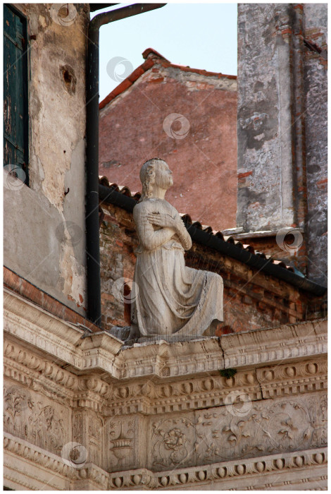 Скачать Фрагмент скульптуры молящегося человека на крыше здания фотосток Ozero