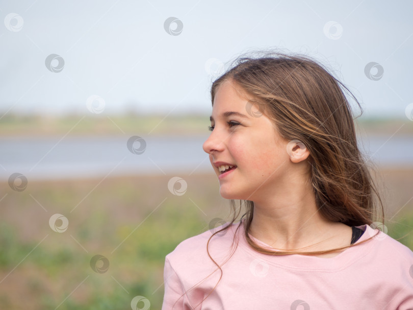 Скачать Улыбающаяся молодая девочка-подросток наслаждается прекрасным весенним лугом. фотосток Ozero