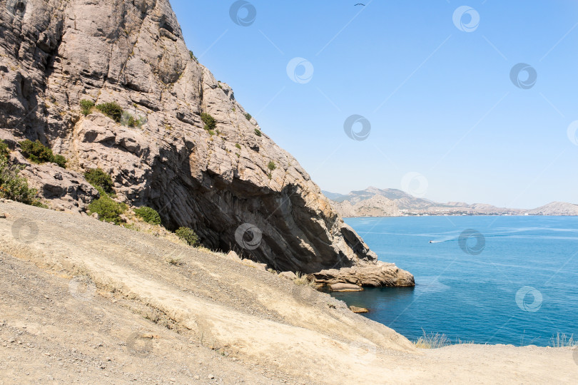 Скачать Высокая каменная скала на берегу моря. фотосток Ozero