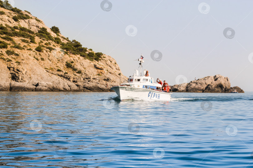 Скачать Лодка плывет вдоль скал. фотосток Ozero