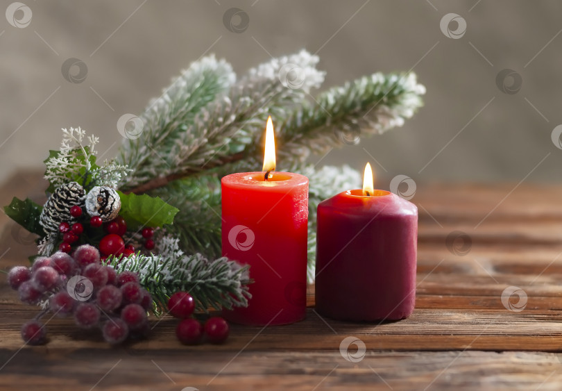 Скачать Крупный план горящих красных свечей wo christmas и ветки рождественской елки на деревянном фоне для Рождества и нового года фотосток Ozero