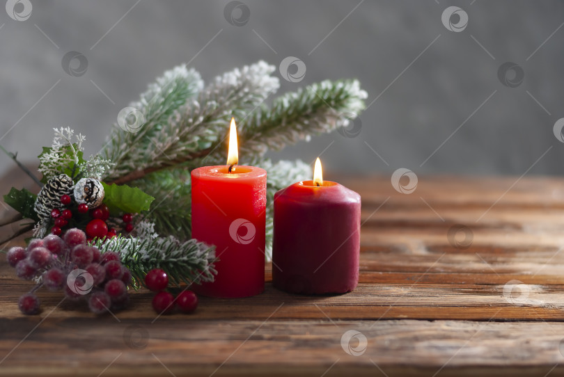 Скачать Две рождественские красные горящие свечи и ветка рождественской елки на деревянном фоне Зимние праздники Рождество и новый год фотосток Ozero