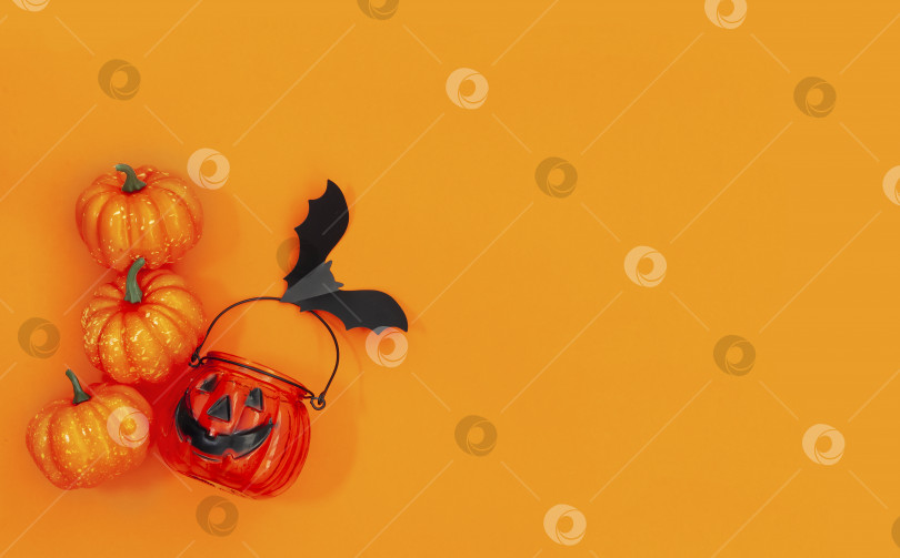 Скачать Плоская тарелка для Хэллоуина с тыквенной миской для конфет и летучей мышью на желто-оранжевом фоне фотосток Ozero