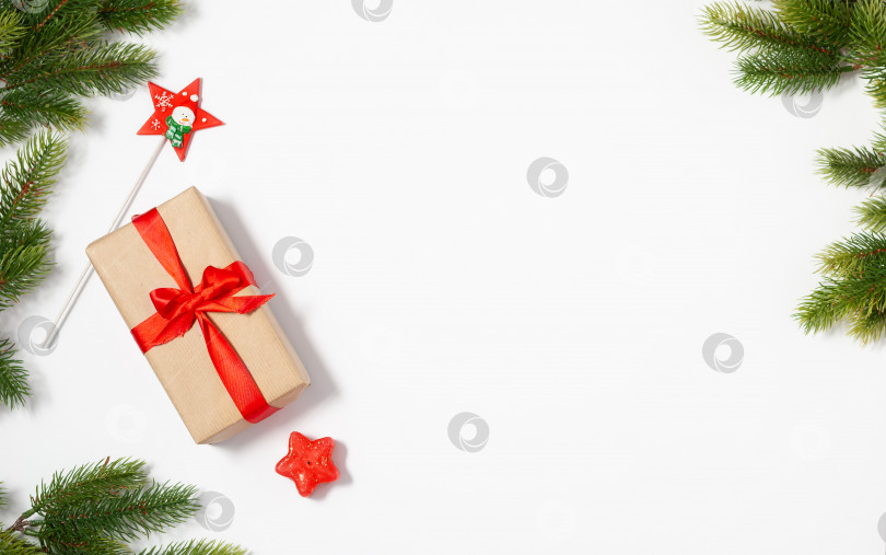 Скачать Рождественская плоская рамка с макетом копировального пространства. Композиция из подарочной коробки и еловых веток на белом фоне фотосток Ozero
