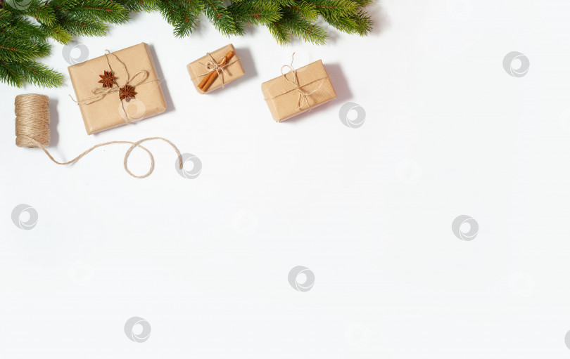 Скачать Рождественская плоская рамка с макетом копировального пространства. Композиция из подарочных коробок и еловых веток фотосток Ozero