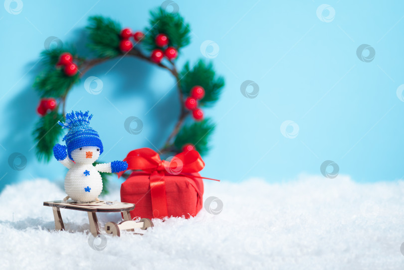 Скачать Рождественская открытка со снежинками и белым снеговиком, доставляющая рождественский подарок в коробке с местом для копирования фотосток Ozero