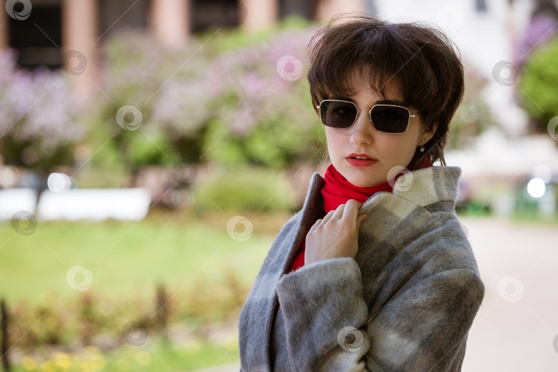 Скачать Портрет молодой женщины в солнцезащитных очках и пальто на фоне кафедрального собора фотосток Ozero