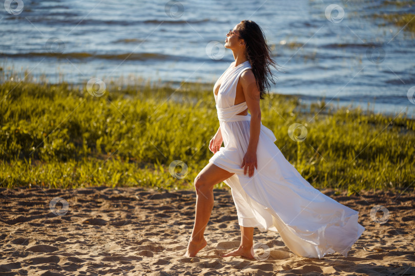Скачать Красивая женщина в белом платье позирует на берегу фотосток Ozero