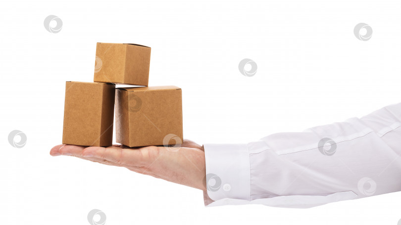 Скачать Три картонные коробки разного размера на ладони мужчины, выделенные на белом фоне фотосток Ozero