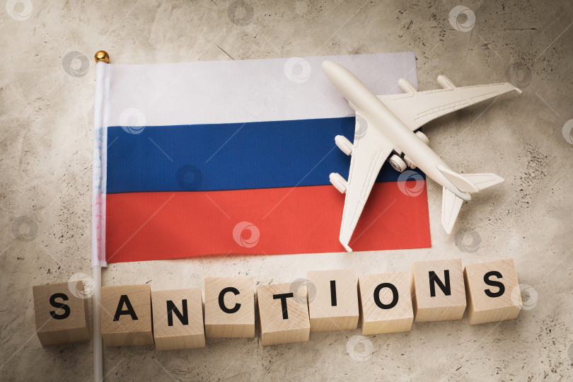 Скачать Флаг России, деревянные кубики с текстом и игрушечный самолет, концепт на тему санкций в России фотосток Ozero
