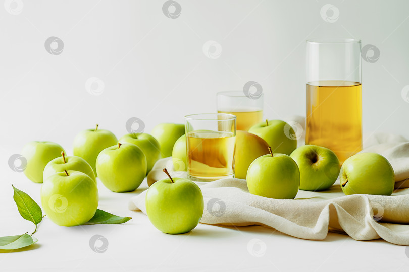 Скачать Зеленые яблоки с яблочным соком в бокалах на белом столе с льняной салфеткой фотосток Ozero