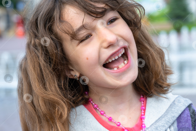 Скачать Беззубая счастливая улыбка девушки с выпавшим нижним молочным зубом c фотосток Ozero