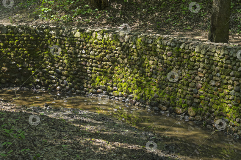 Скачать Каменная стена, укрепляющая русло ручья фотосток Ozero