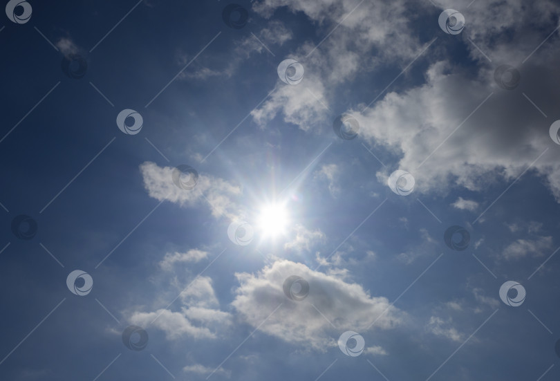 Скачать Солнце с лучами на голубом небе с белыми перистыми облаками. фотосток Ozero