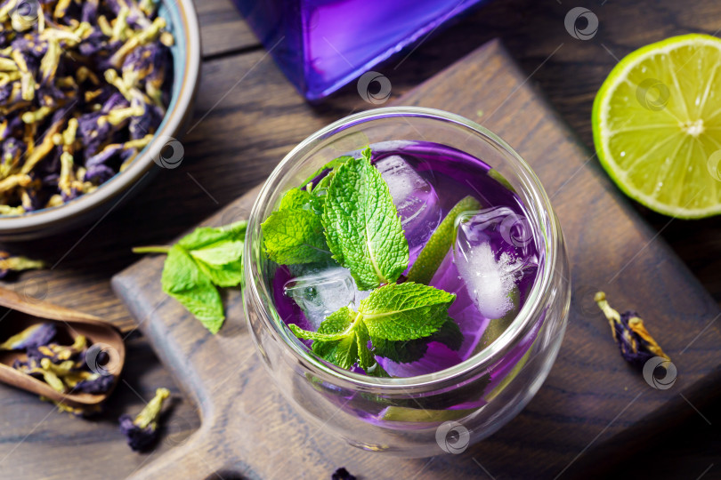 Скачать Освежающий органический чай из голубого и фиолетового горошка-бабочки со льдом фотосток Ozero