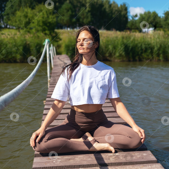 Скачать Женщина, практикующая йогу, медитирует, сидя в позе лотоса фотосток Ozero