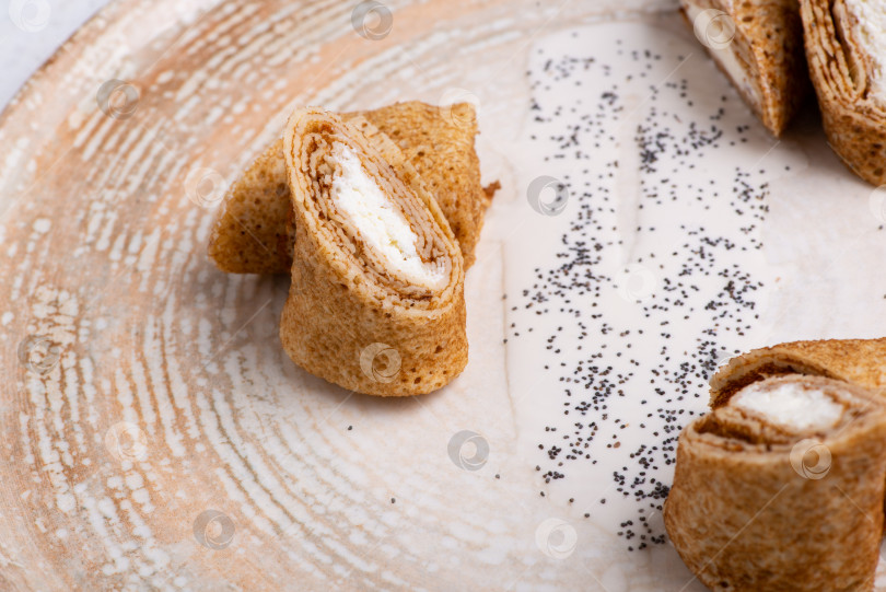 Скачать Тарелка с фаршированными блинчиками с мясом на белом столе фотосток Ozero