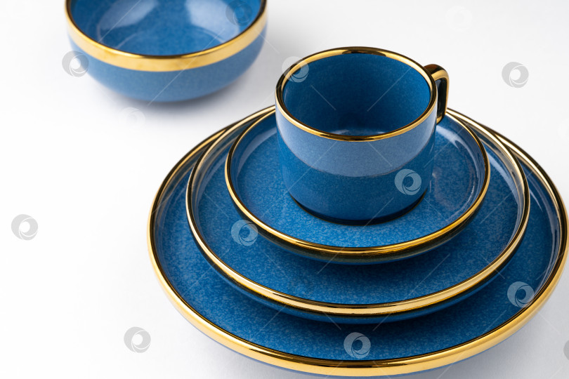 Скачать Набор синих керамических тарелок и чашек на белом фоне фотосток Ozero