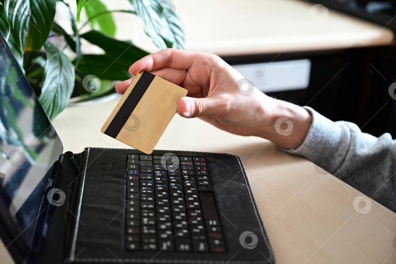 Скачать Руки, держащие кредитную карту и пользующиеся ноутбуком. Покупки в Интернете фотосток Ozero