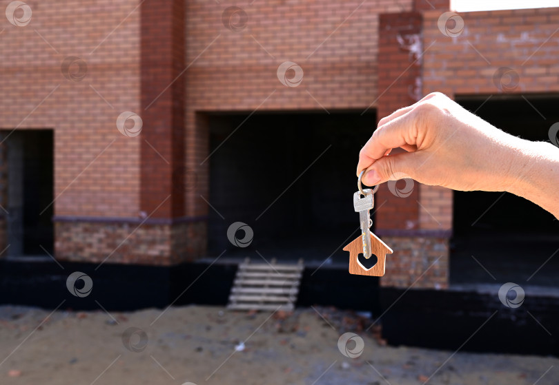 Скачать Женщина держит в руке ключ от нового дома. Одобрение ипотечного кредита жилищный кредит фотосток Ozero