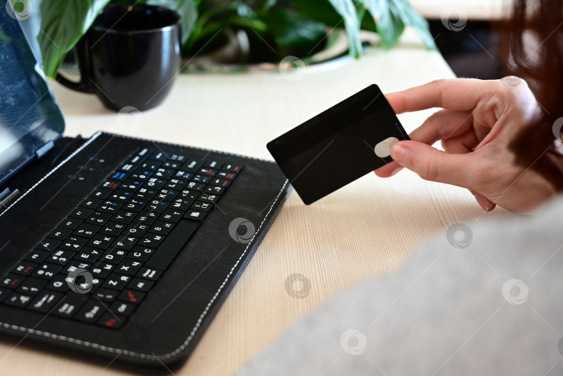 Скачать Руки, держащие кредитную карту и пользующиеся ноутбуком. Покупки в Интернете фотосток Ozero