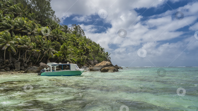 Скачать Лодка пришвартована у побережья тропического острова фотосток Ozero