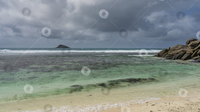 Скачать Волны бирюзового океана вспениваются о риф и накатываются на песчаный пляж. фотосток Ozero