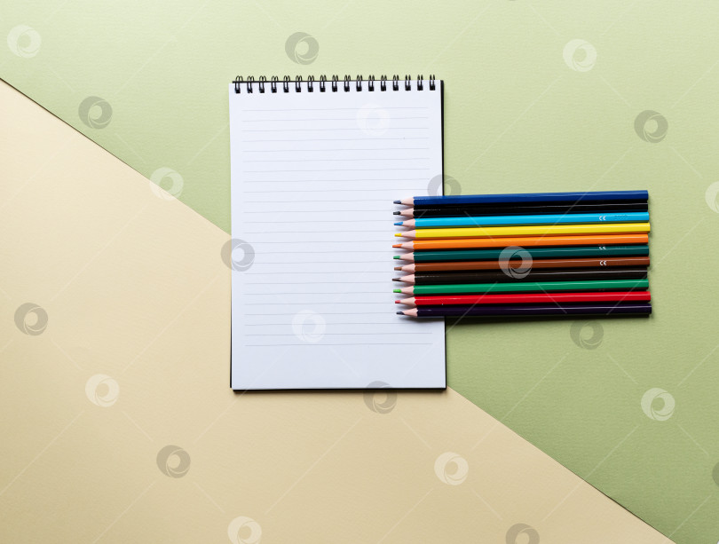 Скачать Цветной карандаш и блокнот на зеленом фоне. фотосток Ozero