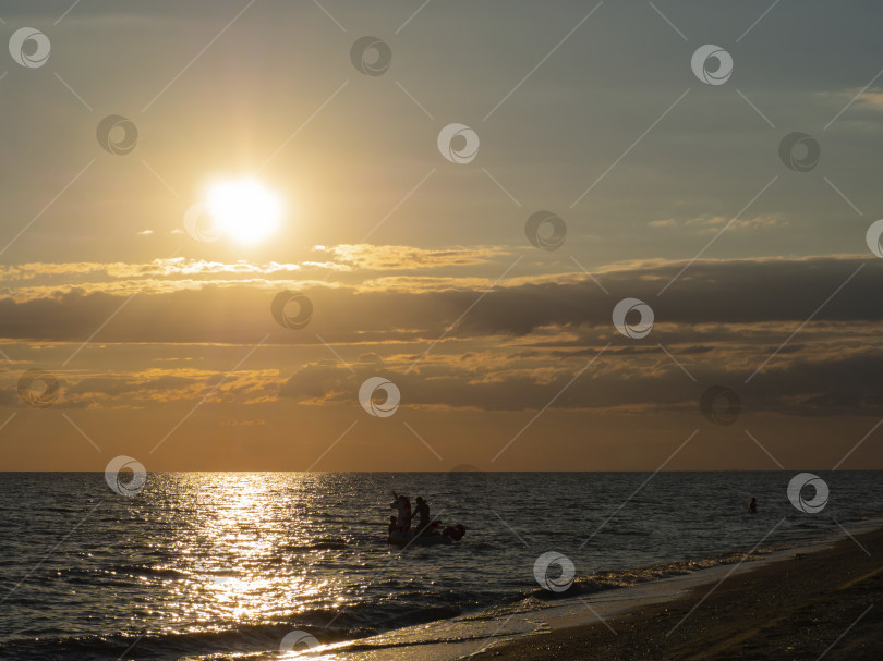 Скачать Счастливые люди в синем море под желтым солнцем рядом с бе фотосток Ozero