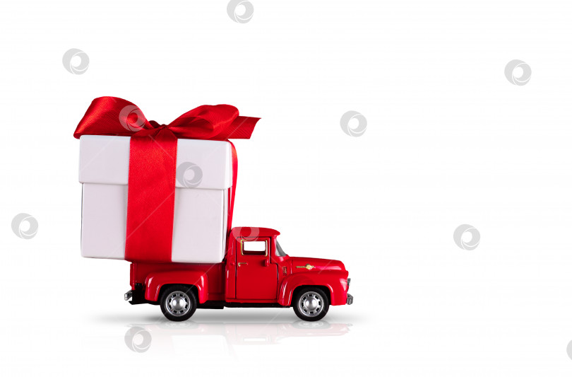 Скачать Красный автомобиль с подарочной коробкой на изолированном белом фоне. Концепция заключается в доставке подарков к праздникам, Дню Святого Валентина, Международному женскому дню, 14 февраля, 8 марта. Покупки, распродажа фотосток Ozero